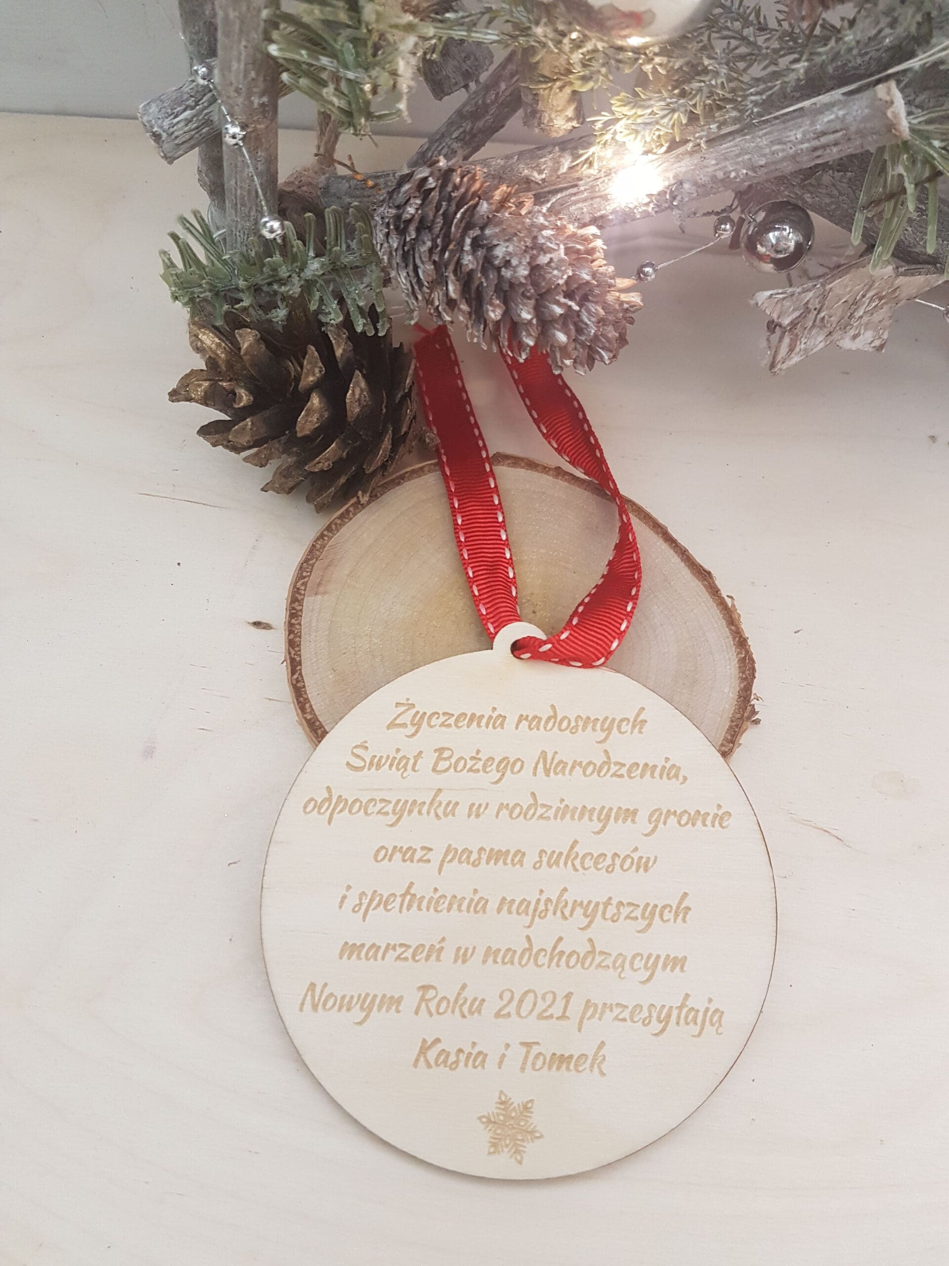Drewniana bombka, zawieszka choinkowa z wygrawerowanymi życzeniami bożonarodzeniowymi